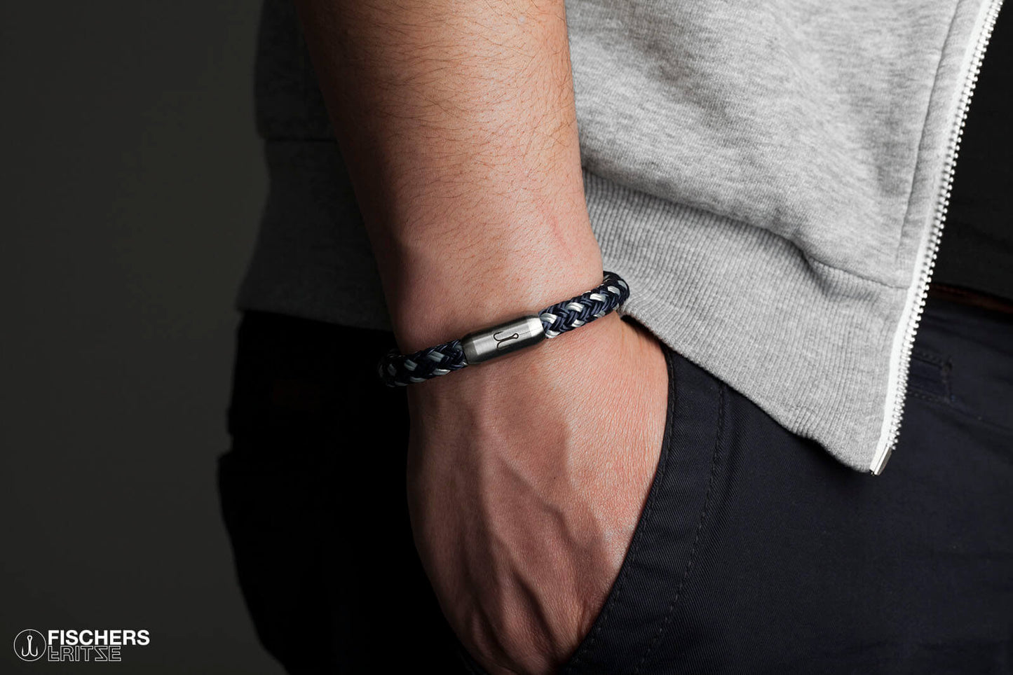 An Handgelenk gelegtes Armband von Fischers Fritze, Segeltau Makrele marineblau silbergrau, Hand in Hosentasche