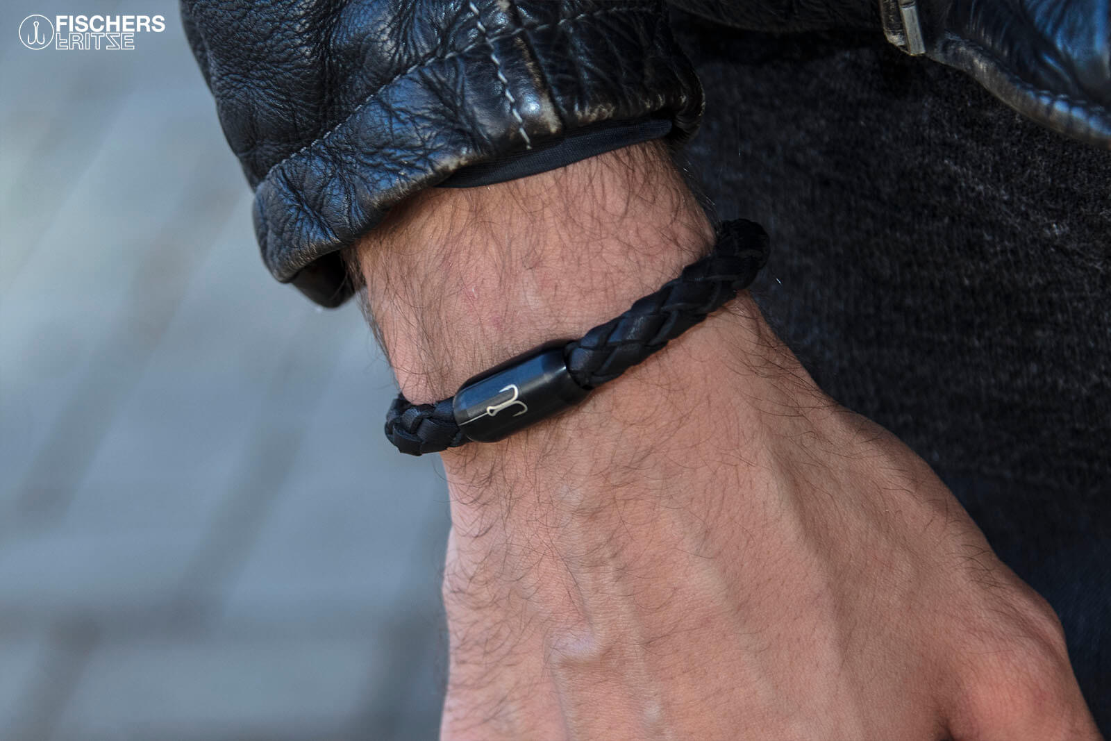 Lederarmband schwarz geflochten angelegt, Torpedomakrele mit schwarzem Magnetverschluss und Angelhaken Gravuren
