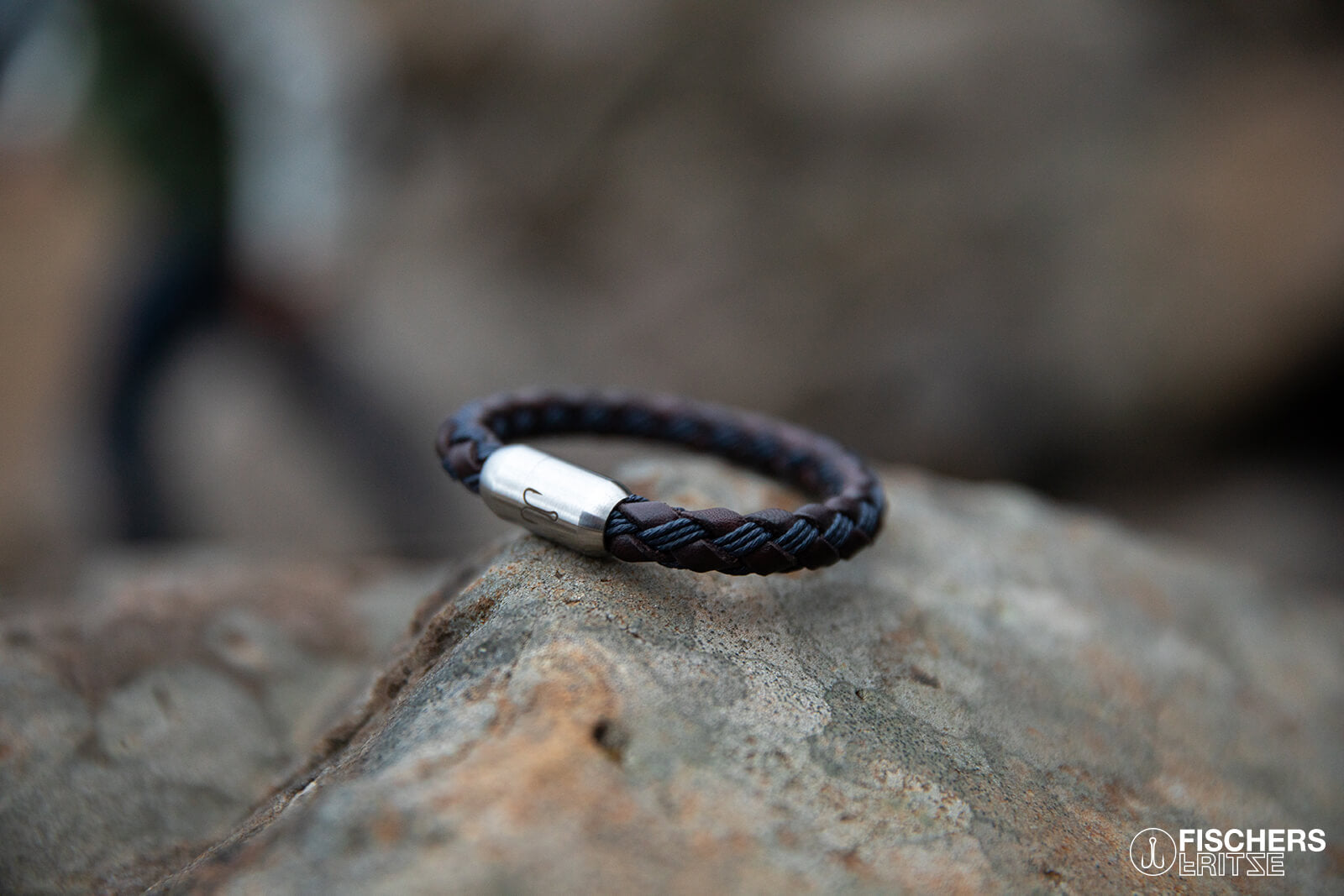 Armband Leder in Kombination mit gewachster Baumwolle liegt geschlossen auf Felsenklippe