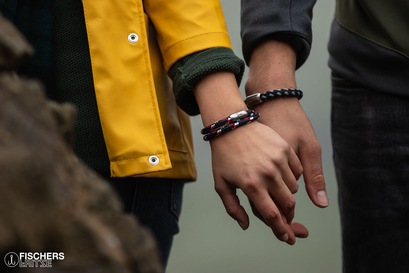 Frau und Mann wandern Hand in Hand und tragen maritimes Segeltau-Armband von Fischers Fritze als Armschmuck
